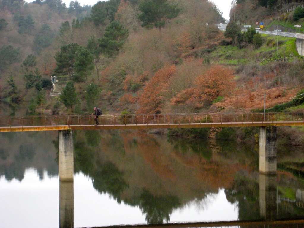 A lone pilgrim crossing a bridge